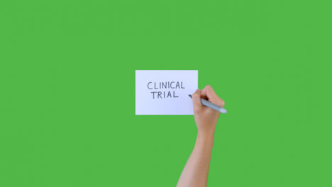 Frau-Schreibt-Klinische-Studien-Auf-Papier-Mit-Grünem-Bildschirm